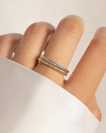 model wearing a sterling silver spiral ring layered with the same stacking ring in gold