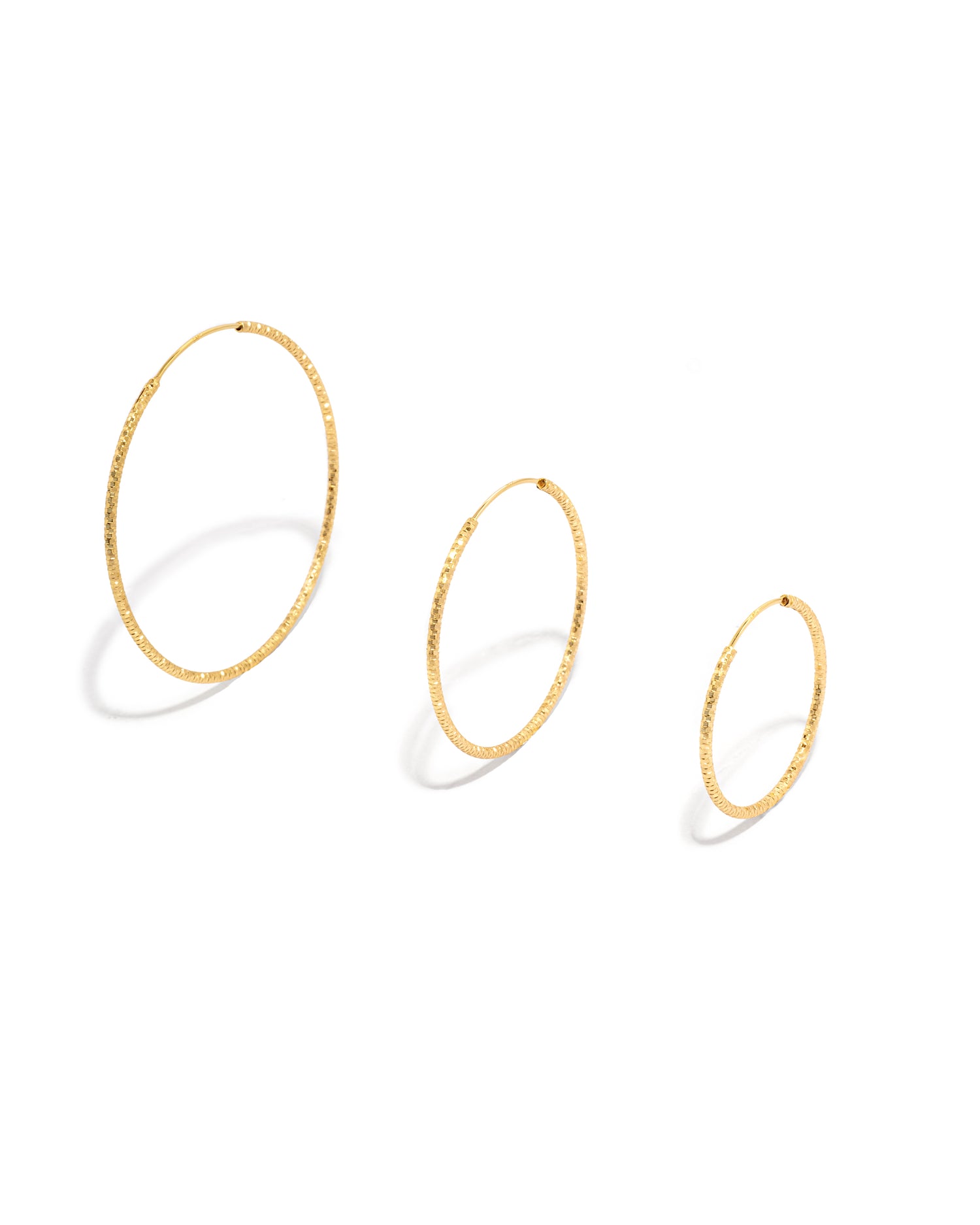 simple gold hoops on a white background showcasing the different sizes the come in