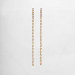 clse up of gold dangle earrings with a smooth, slender line of sparkling cubic zirconia, perfect for bridal earrings or wedding jewelry.