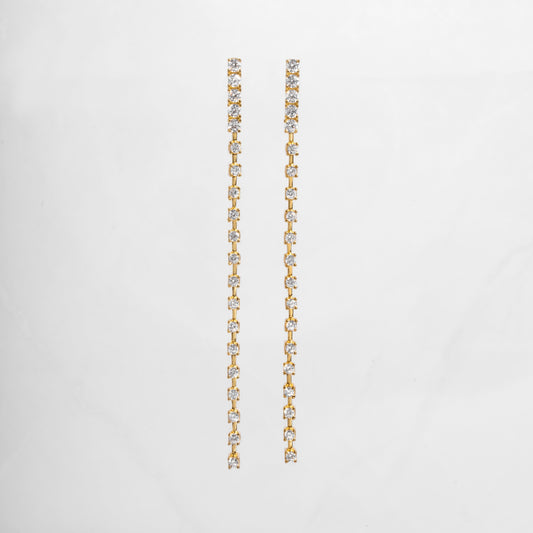 clse up of gold dangle earrings with a smooth, slender line of sparkling cubic zirconia, perfect for bridal earrings or wedding jewelry.