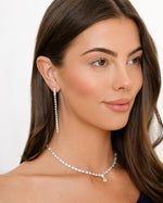 Model wearing sterling silver drop earrings and a diamond tennis necklace