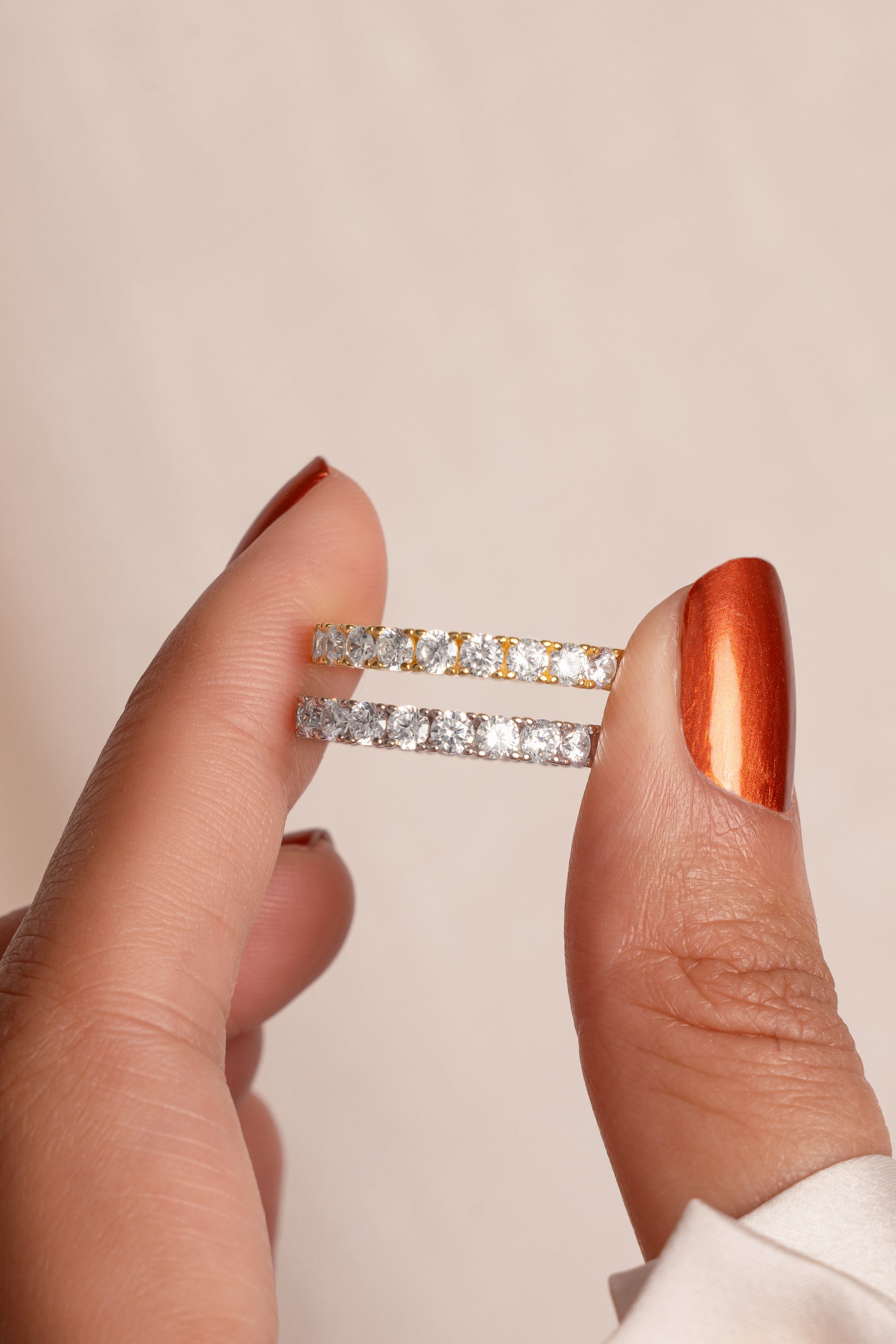 Model holding gold and silver statement diamond cz eternity rings. 