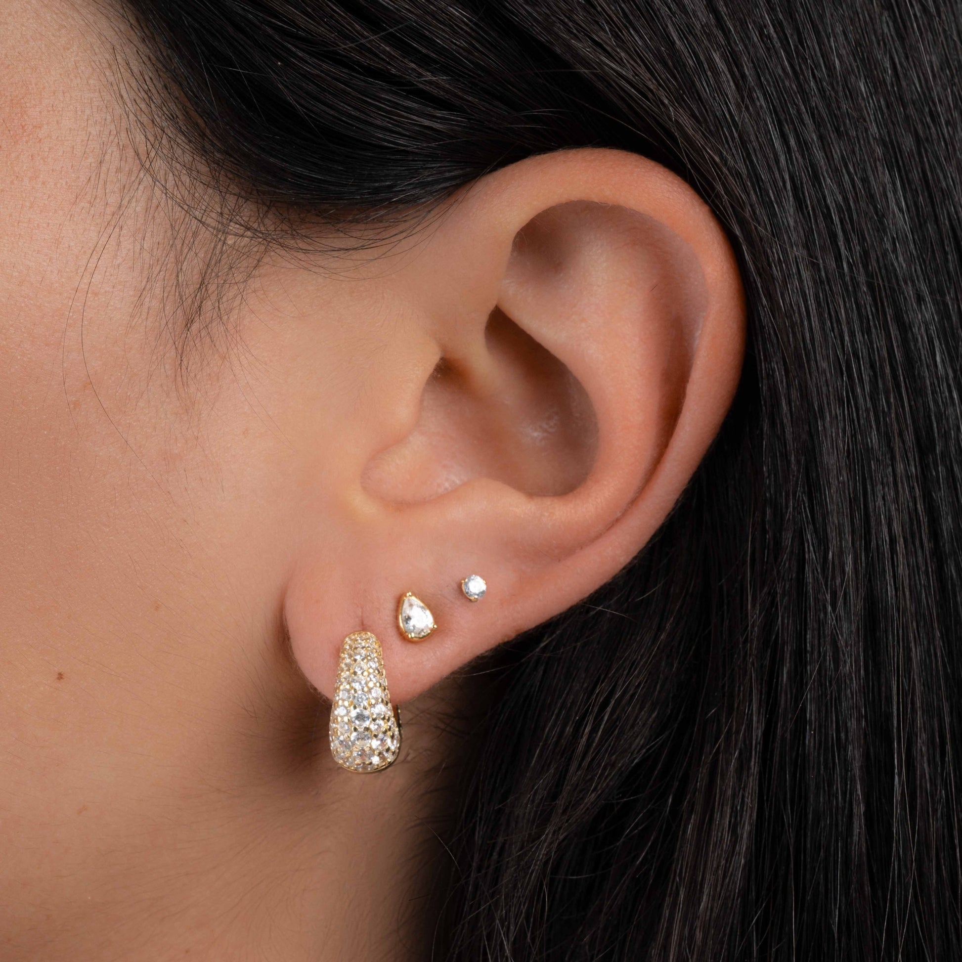 Model wearing 14k gold plated diamond earrings featuring chunky gold hoop earrings