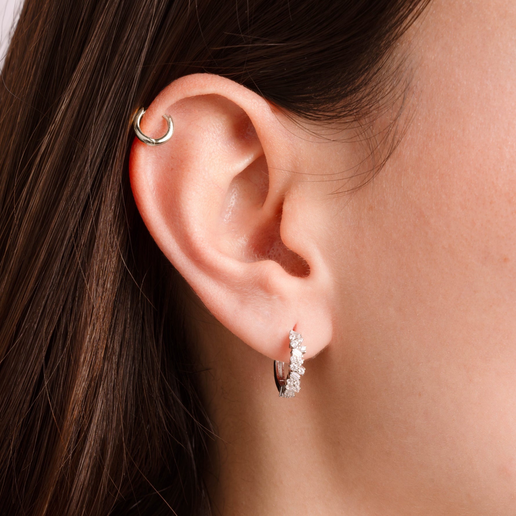 Model wearing sterling silver huggie earrings with diamonds