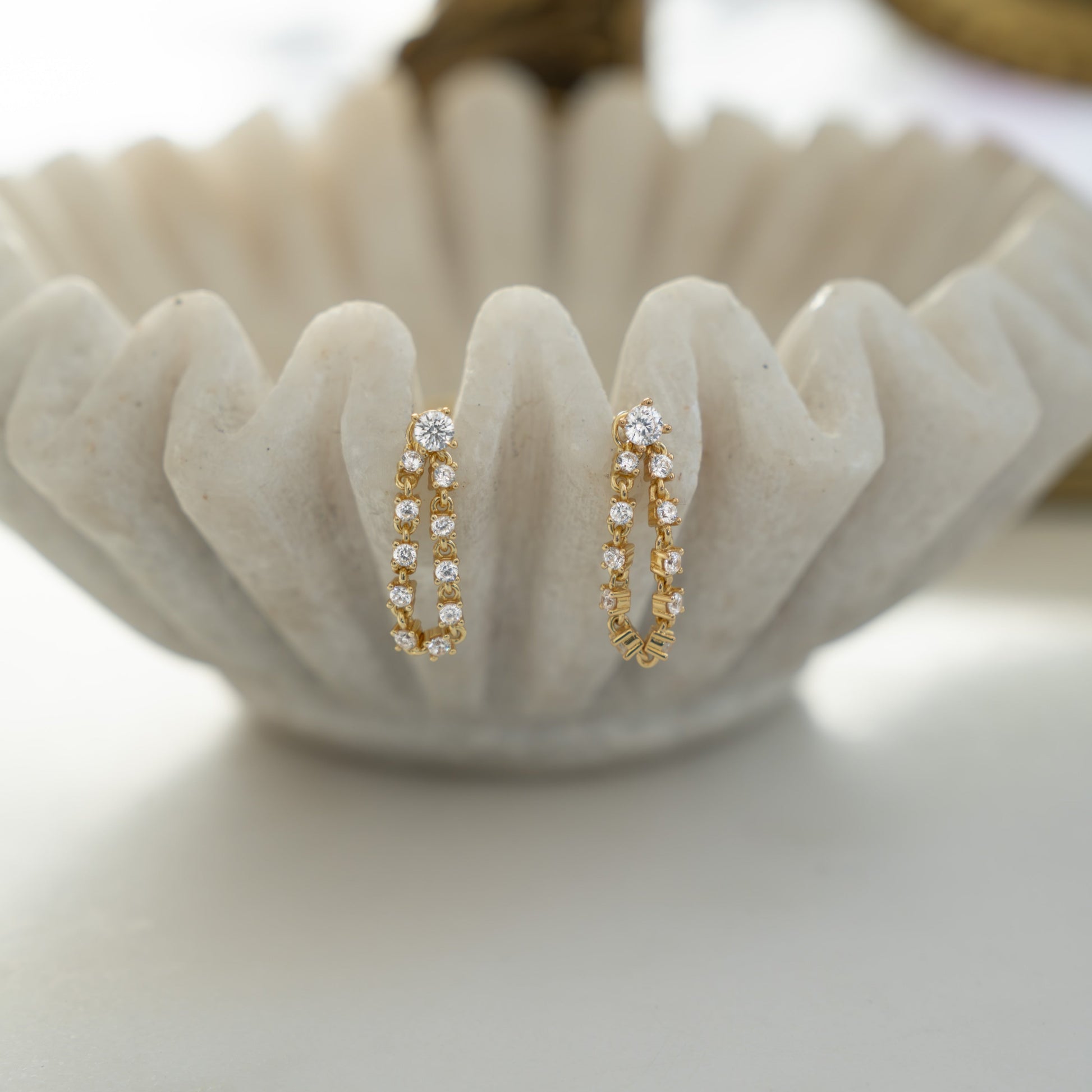 Close-up of gold tennis chain link stud earrings, showcasing its delicate chain, perfect as front back earrings.