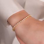 model wearing minimalist tennis bracelet in gold 
