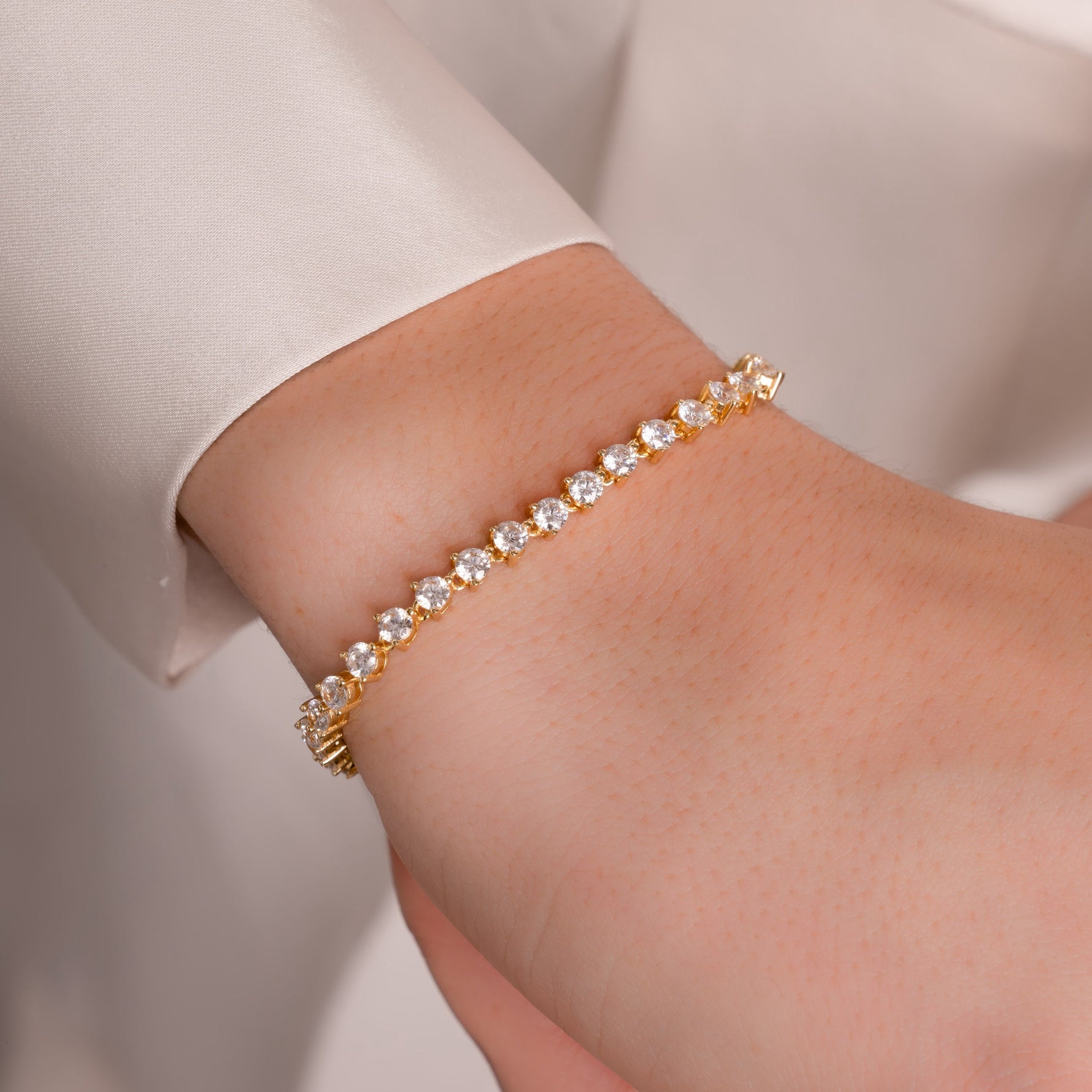 model wearing minimalist tennis bracelet in gold 
