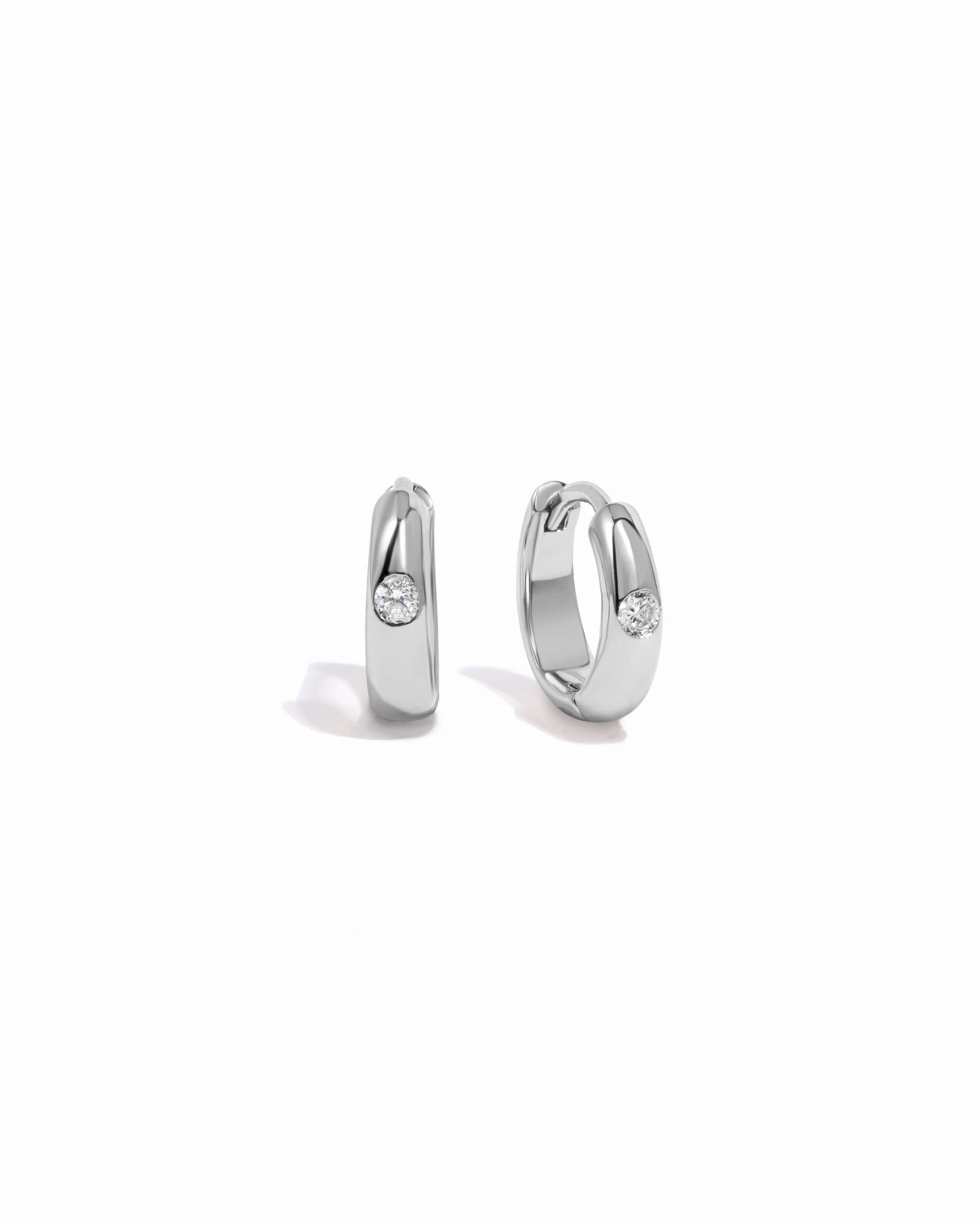 silver hoop earring featuring a dome style earring design and a cubic zirconia stone