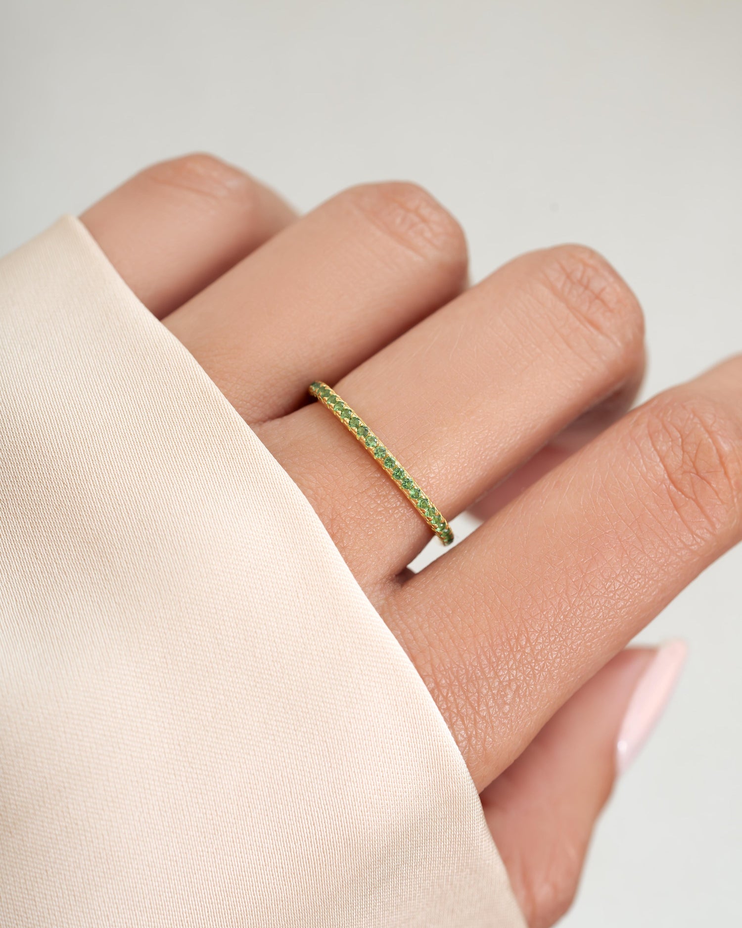 Green diamond stacking eternity ring on model
