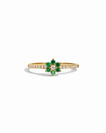 Gold ring with emerald green gemstone on a white background