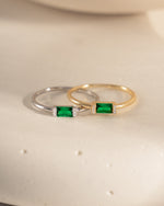 closeup image of sterling silver emerald baguette ring and 14k gold plated emerald green ring