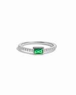 Silver ring with a emerald gemstone on a white background