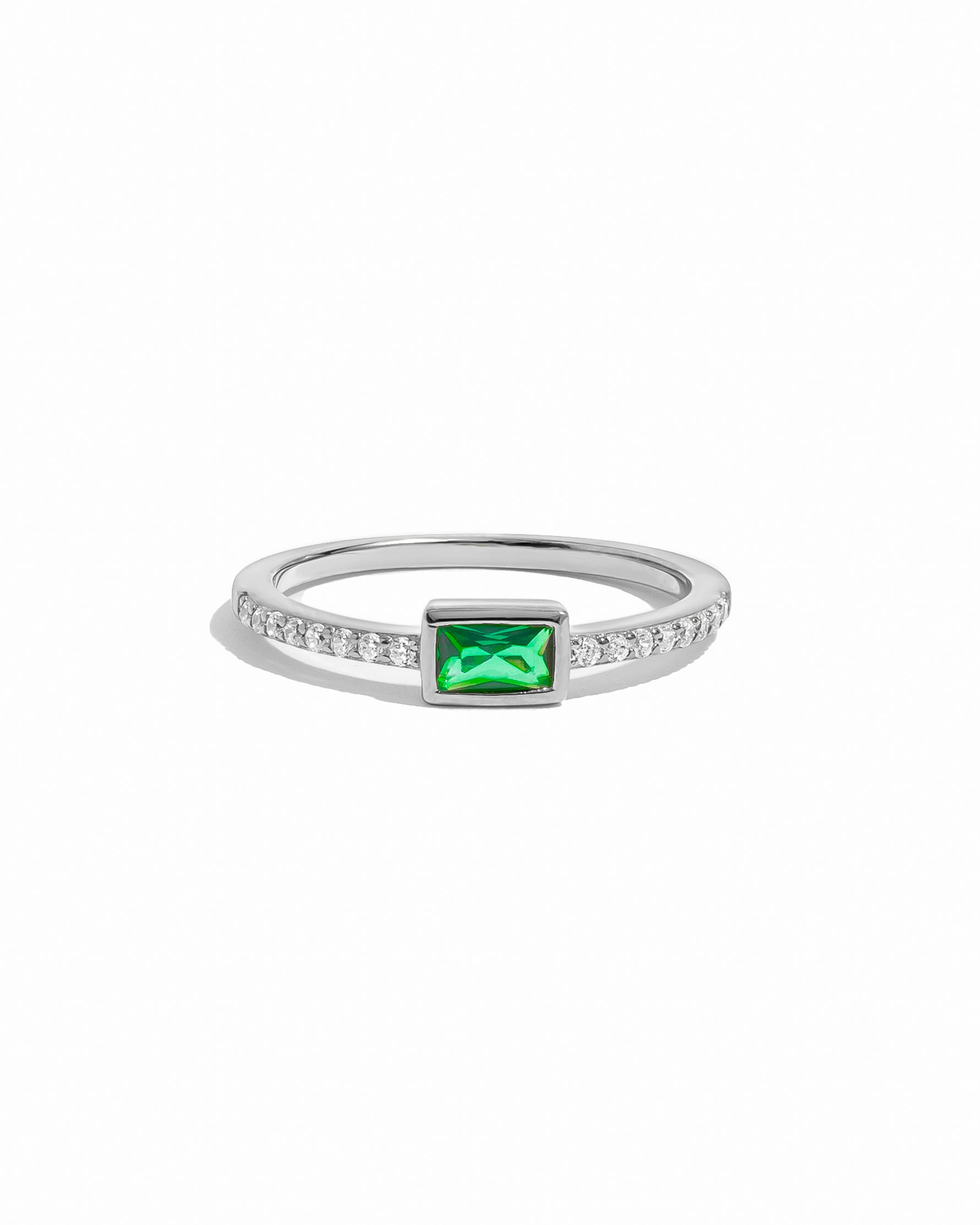 Silver ring with a emerald gemstone on a white background