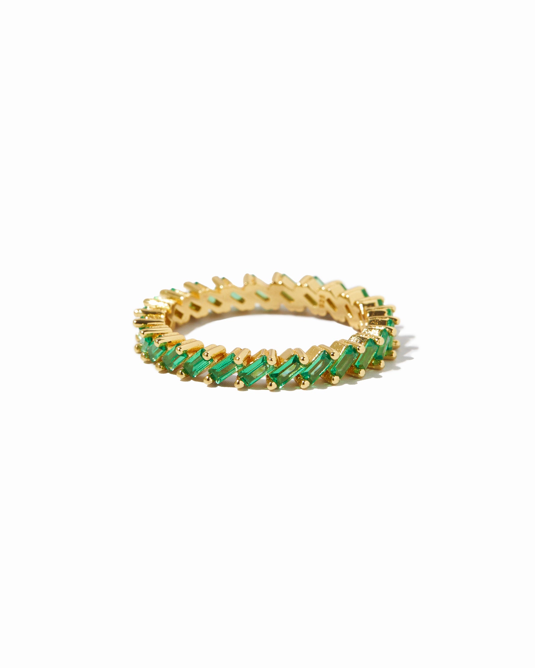Gold emerald statement slanted baguette ring on white background