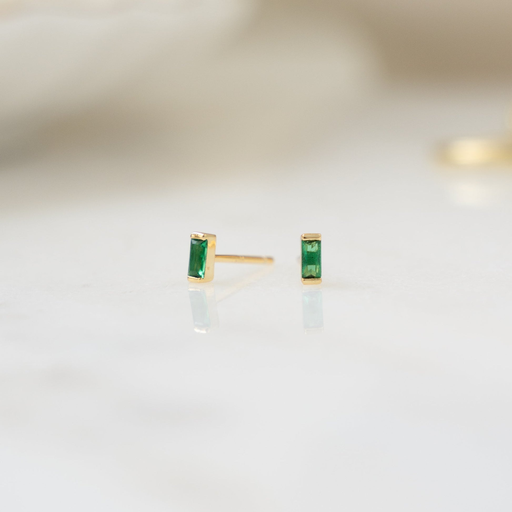 closeup image of gold emerald earrings