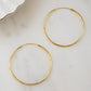 Closeup image of large hoop earring with threader earring closure style