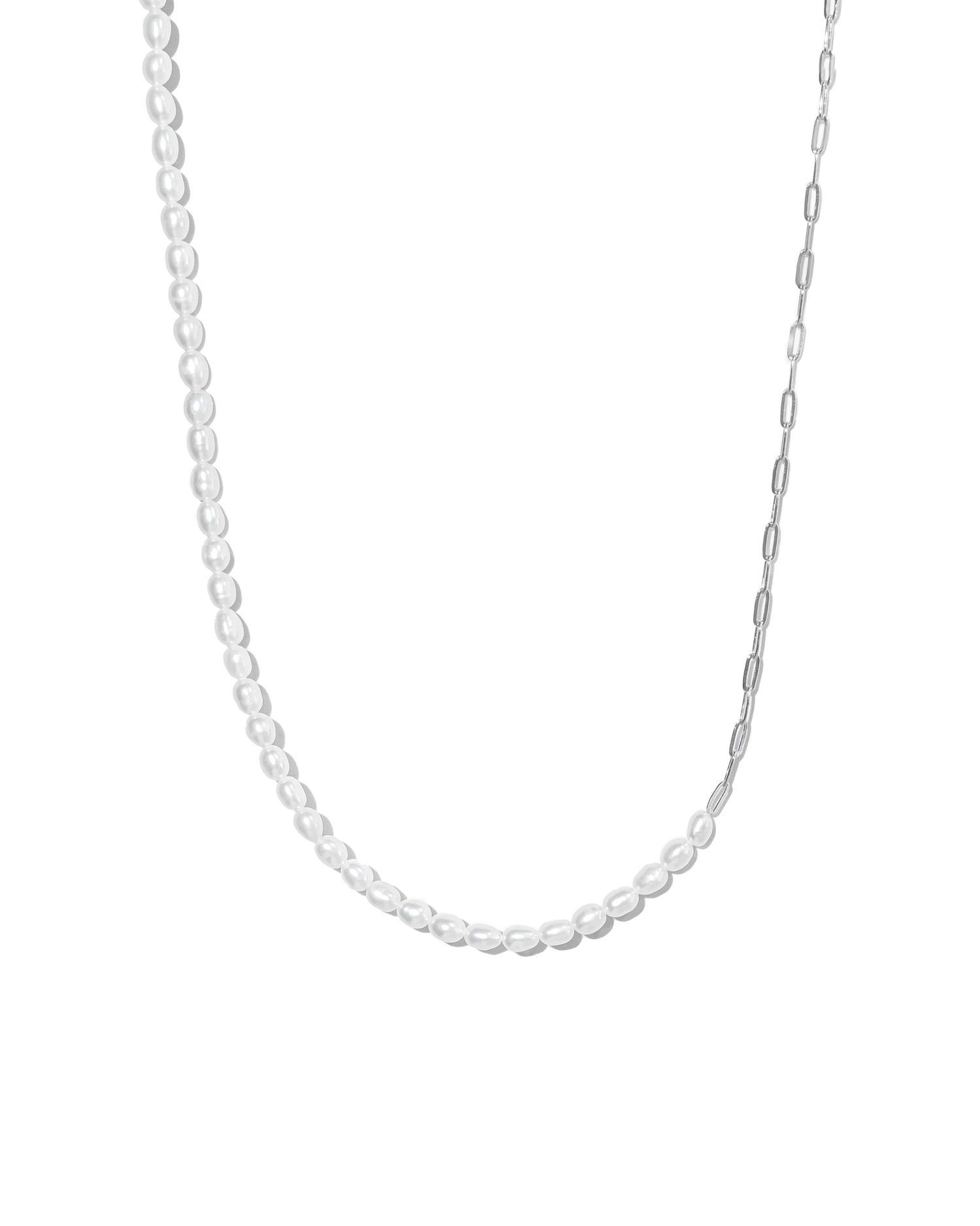 Closeup image of silver paperclip chain and freshwater pearl necklace on white background 