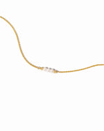 Gold chain bracelet with small pearl beads on a white background