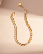 gold chain stackable bracelet on a pink background