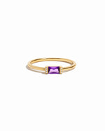 Gold ring with a amethyst birthstone gemstone on a white background