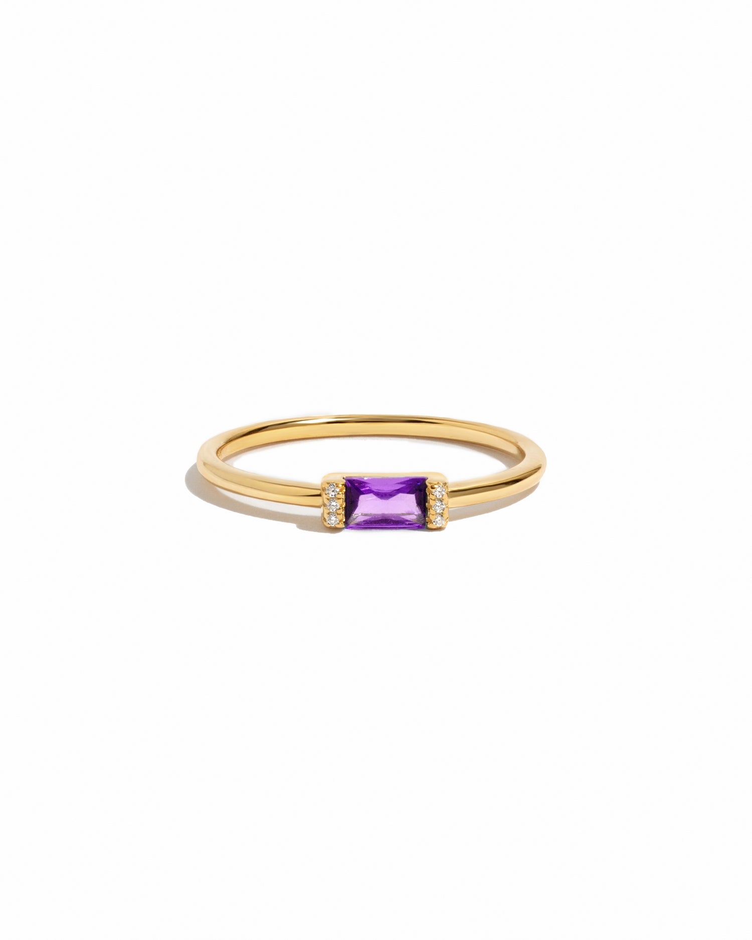 Gold ring with a amethyst birthstone gemstone on a white background
