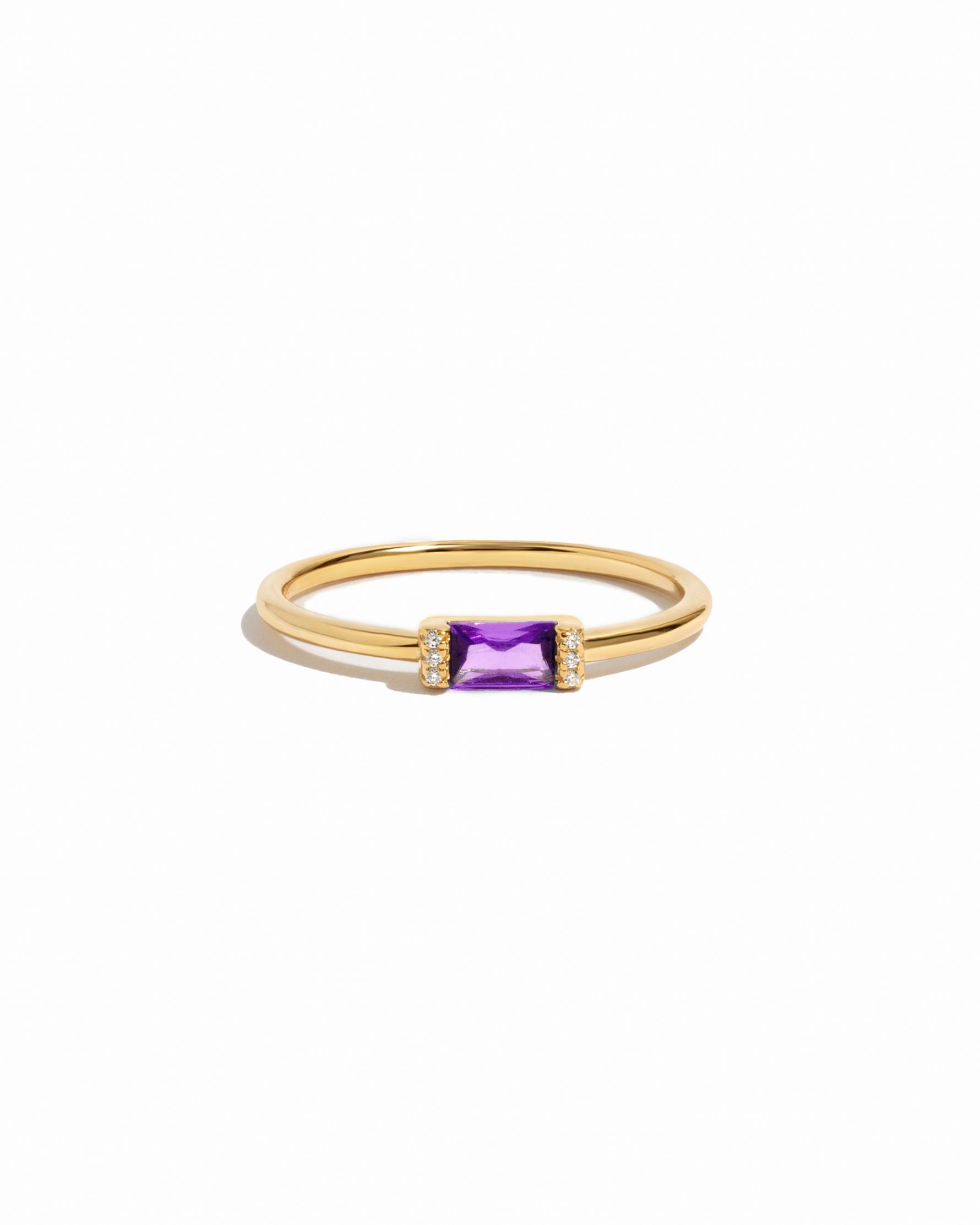 Gold ring with a amethyst birthstone gemstone on a white background