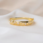closeup image of thick bangle bracelet with studded pearl design