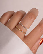 Close-up of a plain beaded gold ring and a plain beaded silver dainty ring 
