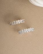 Gold dainty promise ring and sterling silver diamond ring on beige background