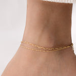 Model wearing a delicate gold anklet set