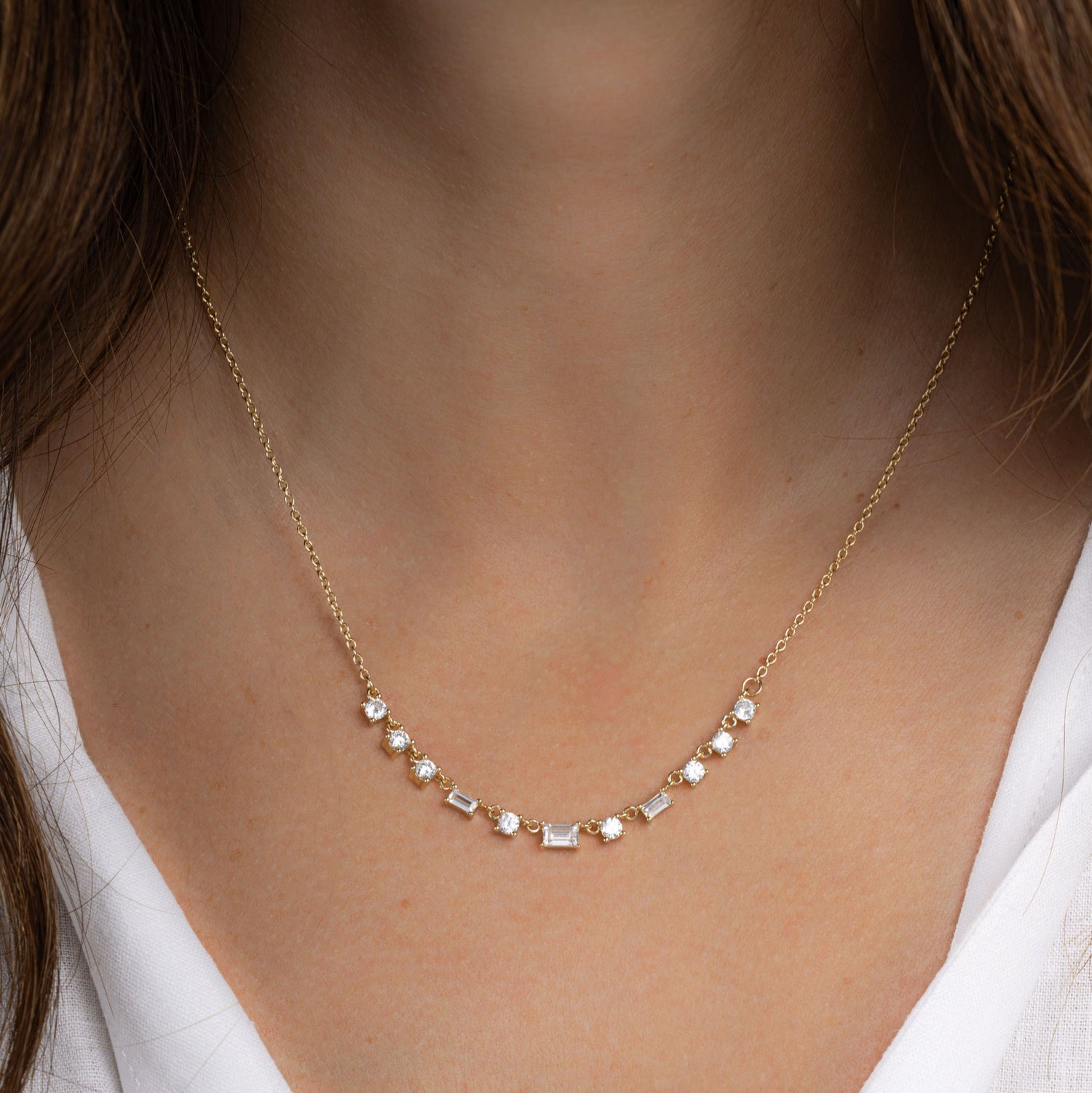 Model wearing sami jewels gold delicate necklace with diamond baguettes