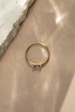 Overhead view of a gold simple stacking ring with a baguette cut birthstone