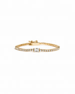 Gold bracelet with a baguette diamond on a white background