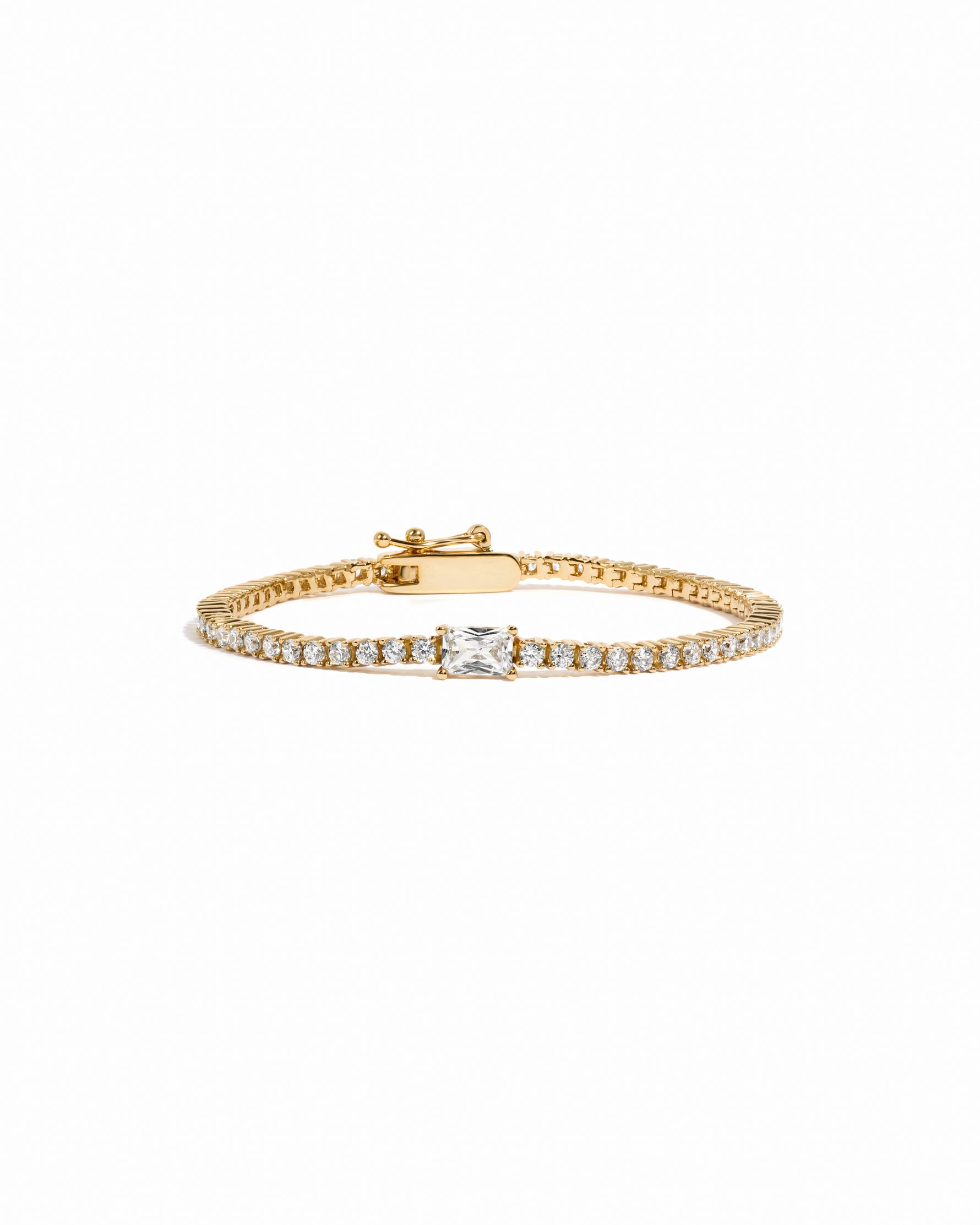 Gold bracelet with a baguette diamond on a white background