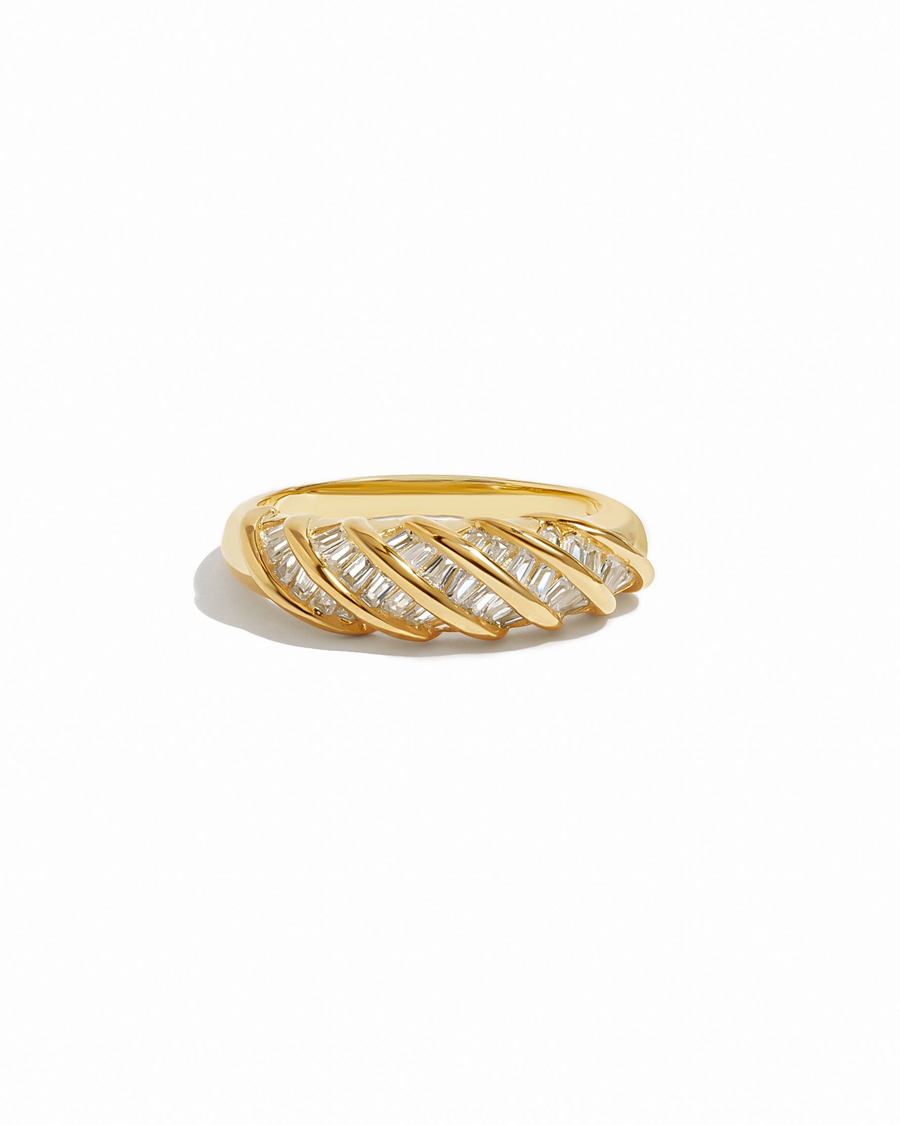 Gold croissant ring with baguette diamond accents on a white background