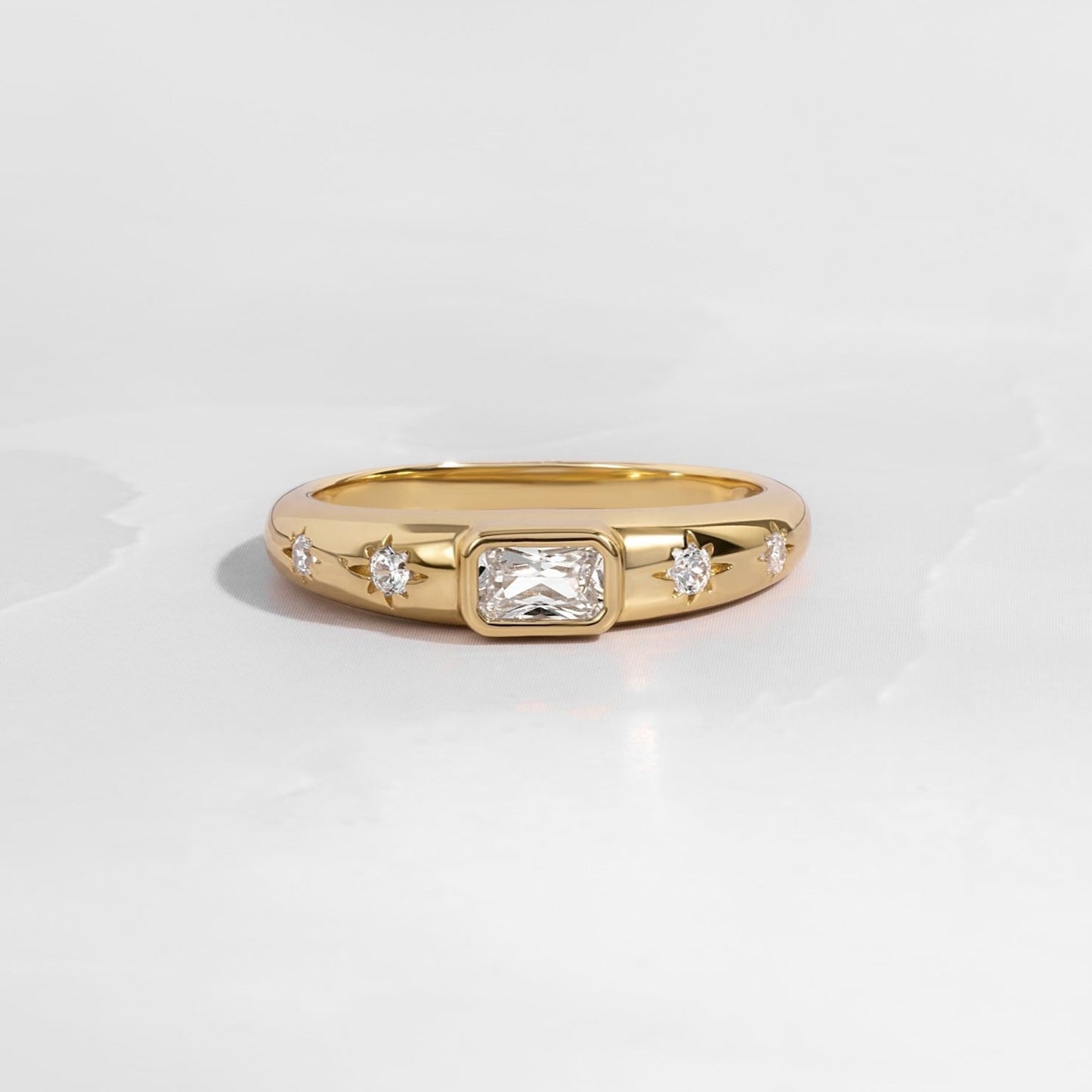 Gold baguette starburst band with tiny diamonds on white background