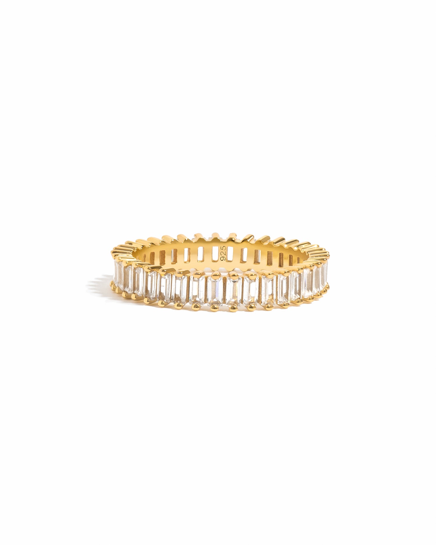 Gold ring with baguette cut gemstones on a white background