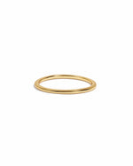 Thin plain gold stacking band on white background.