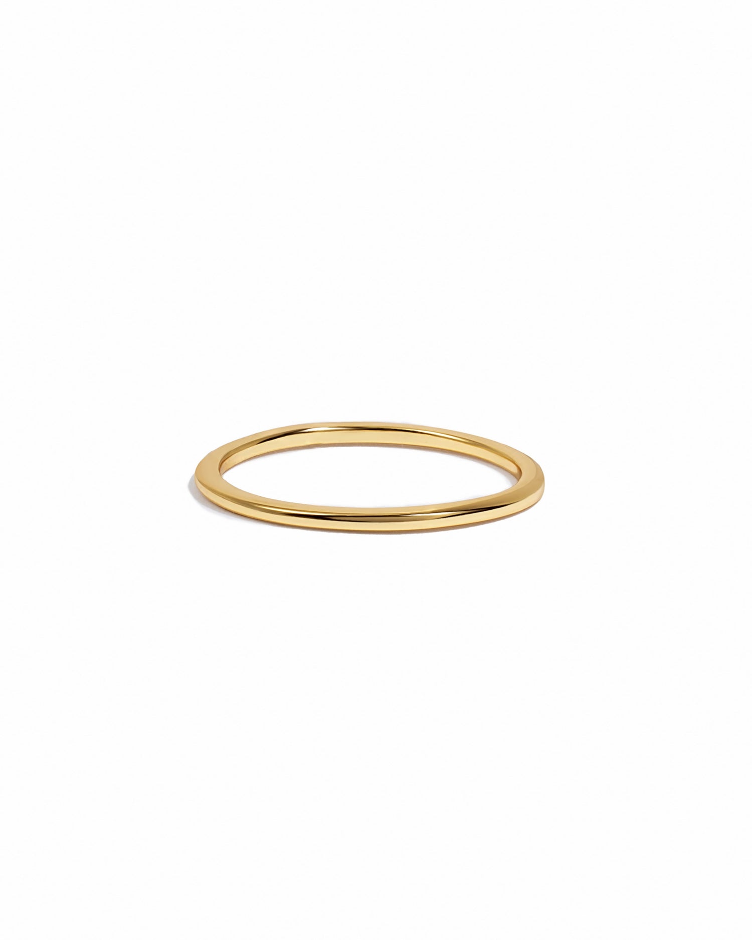 Thin plain gold stacking band on white background.