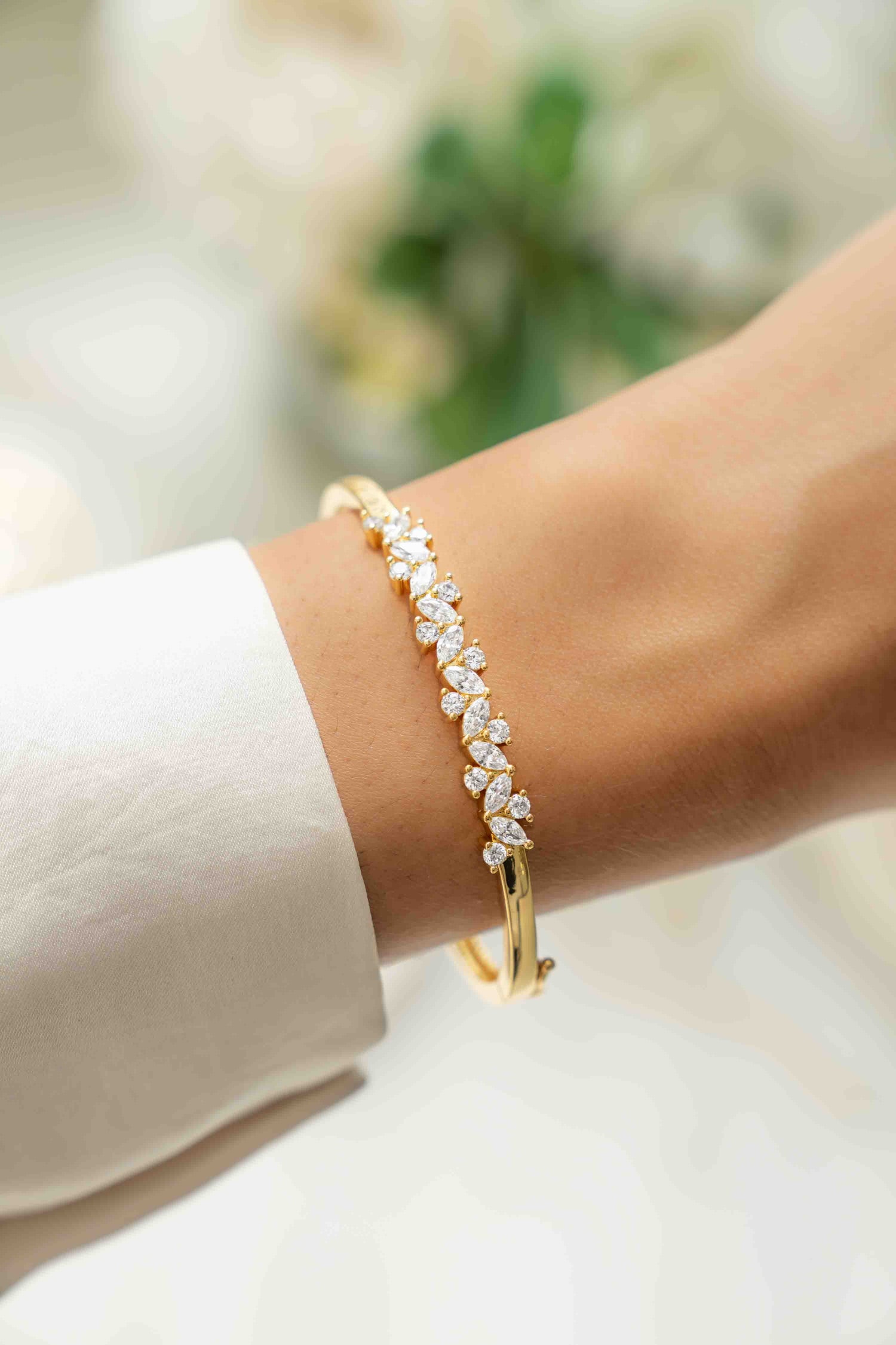 Model wearing 14k gold plated bangle bracelet with cubic zirconia stones