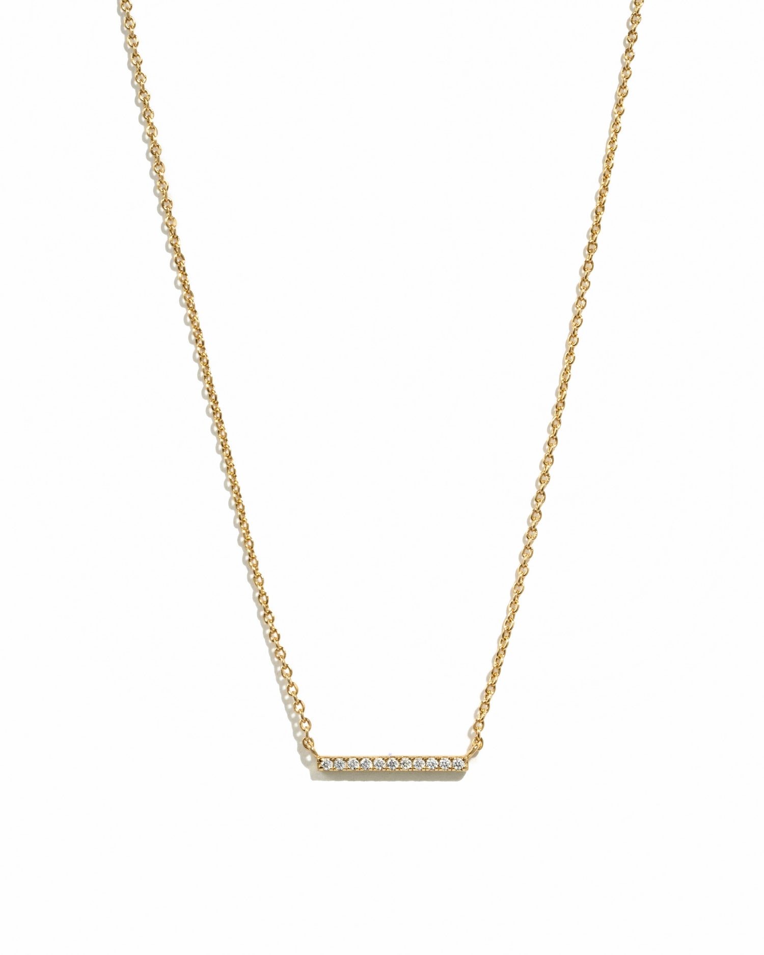 Gold necklace with a bar pendant on a white background