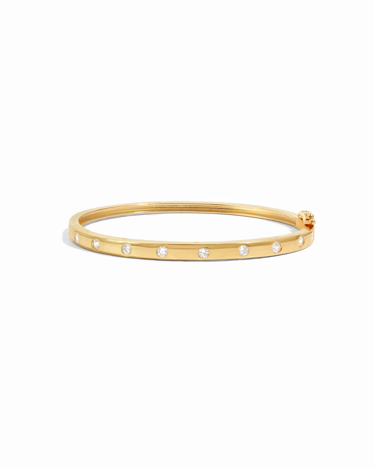 Gold diamond bangle with small cubic zirconia stones on a white background