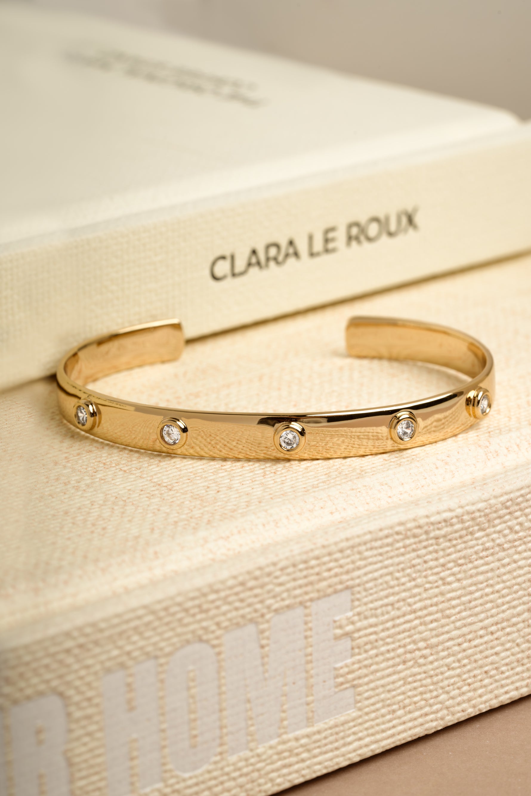 Gold adjustable arm cuff bracelet on decorative book