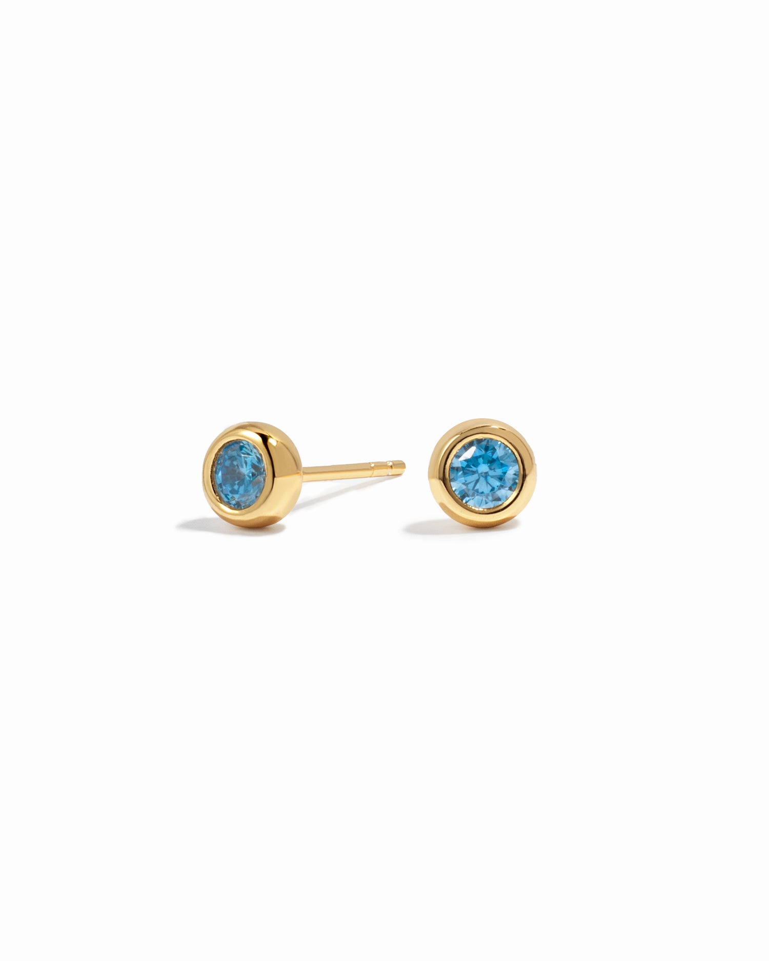 Gold aquamarine earrings on a white background