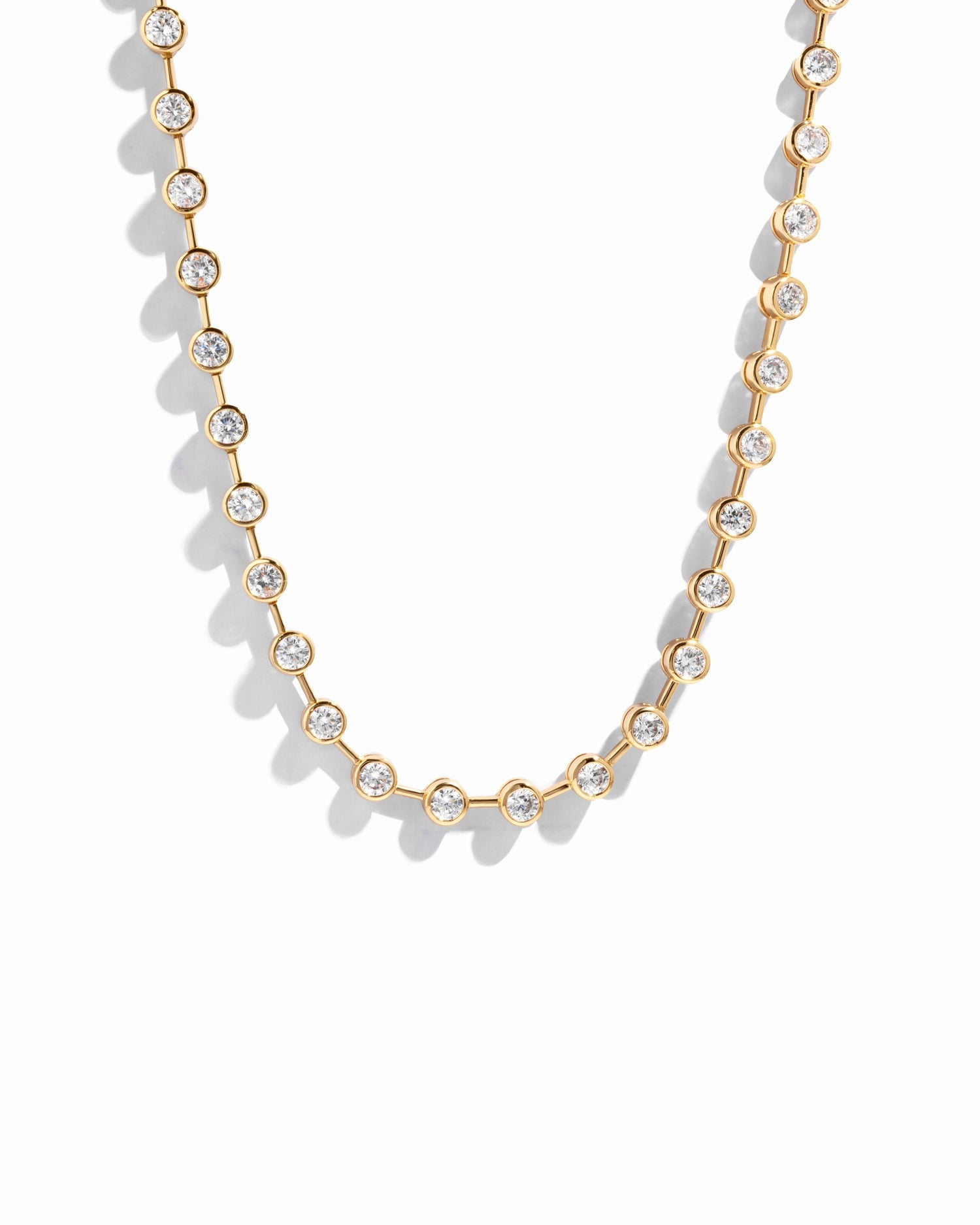 Gold bezel tennis necklace by Sami Jewels featuring a sleek, elegant design with a chain of sparkling gemstones.
