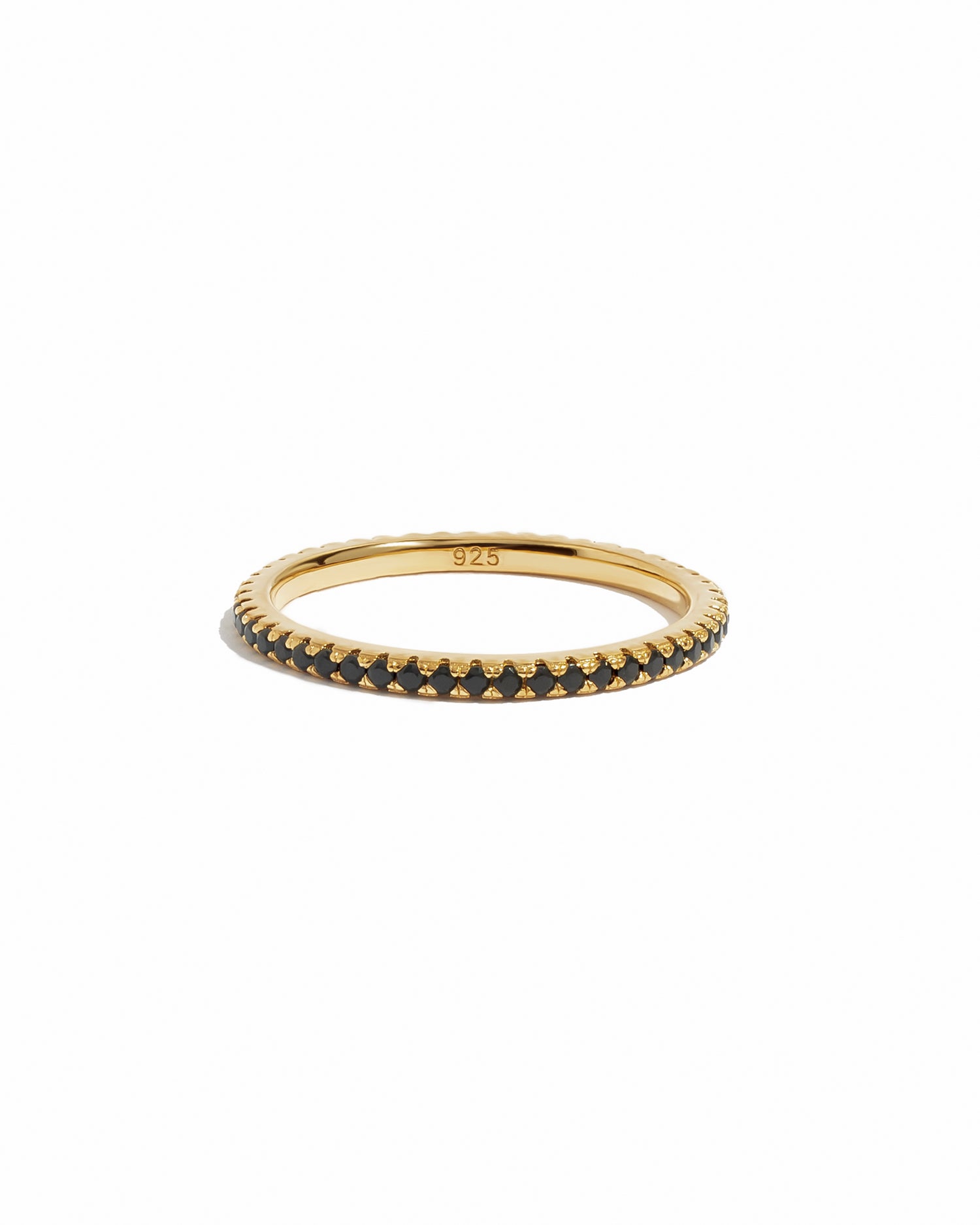 Gold eternity ring with black stones on a white background