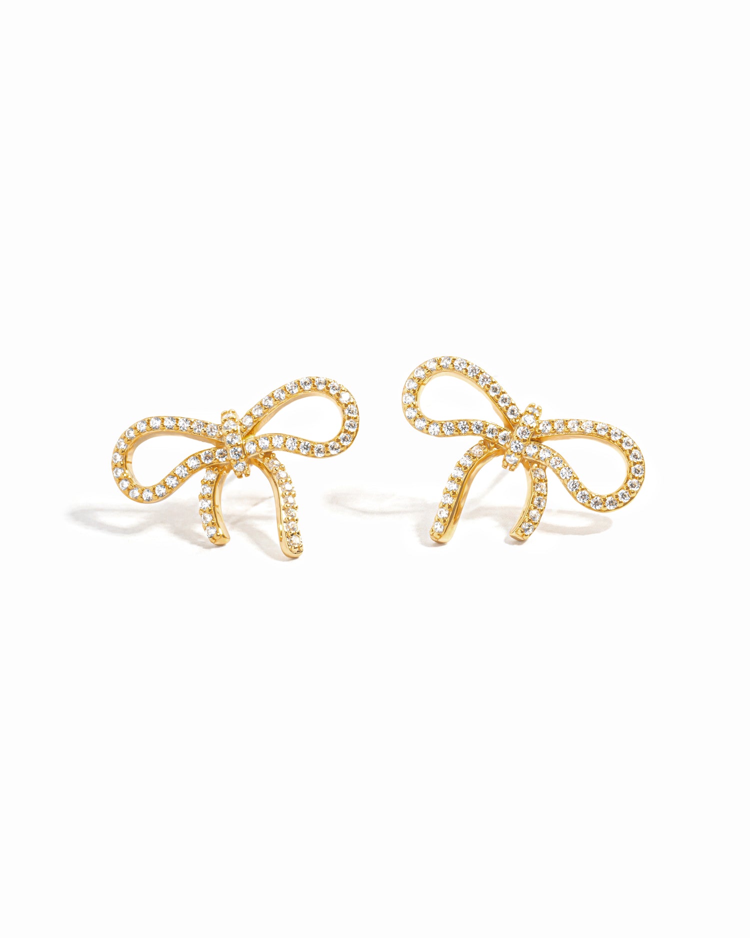 flat lay of diamond earrings, featuring a bow-shaped design with sparkling cubic zirconia stones.
