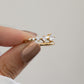 Closeup of hand holding Sami Jewels gold plated bypass spiral ring with 5 CZ diamonds