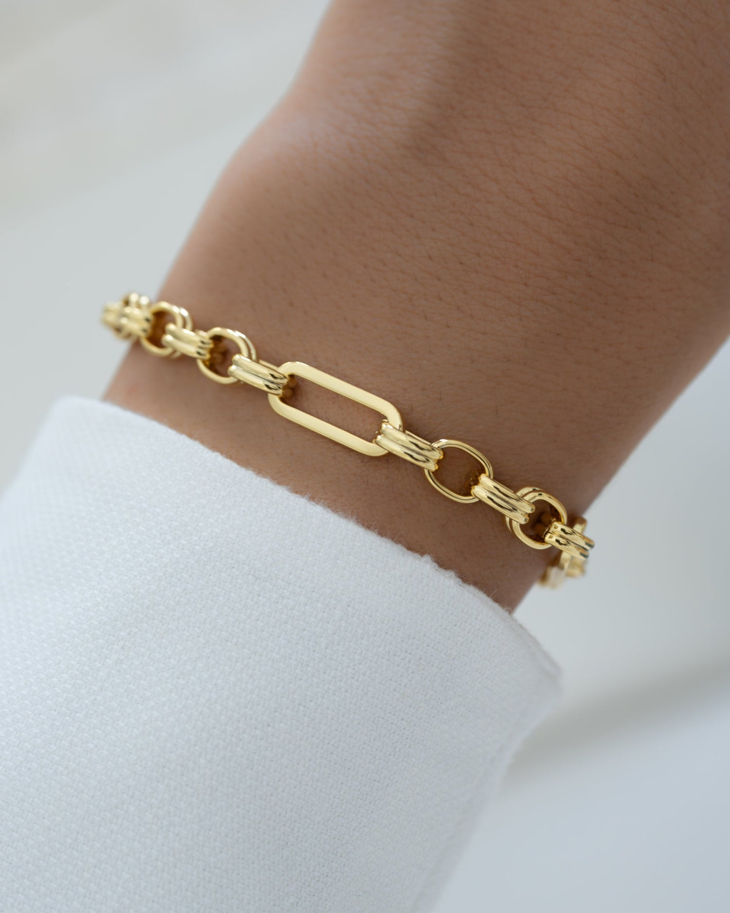 Gold chain paperclip bracelet on a wrist 