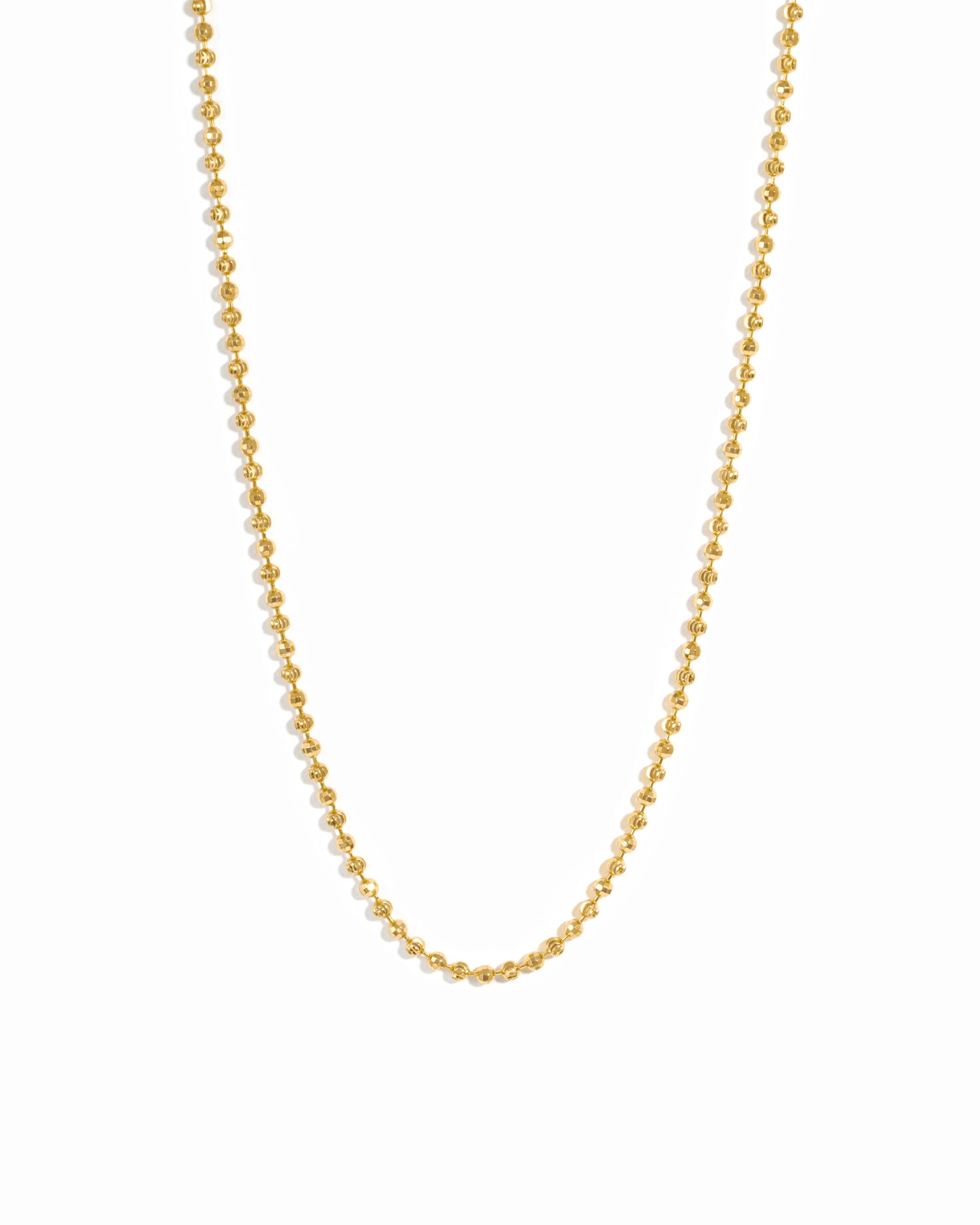 Gold beaded necklace on white background